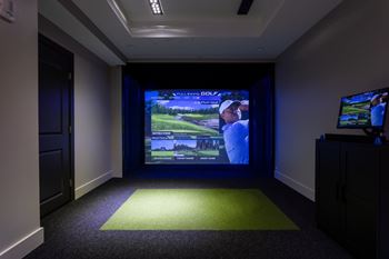 Indoor golf simulator with projection screen and putting area